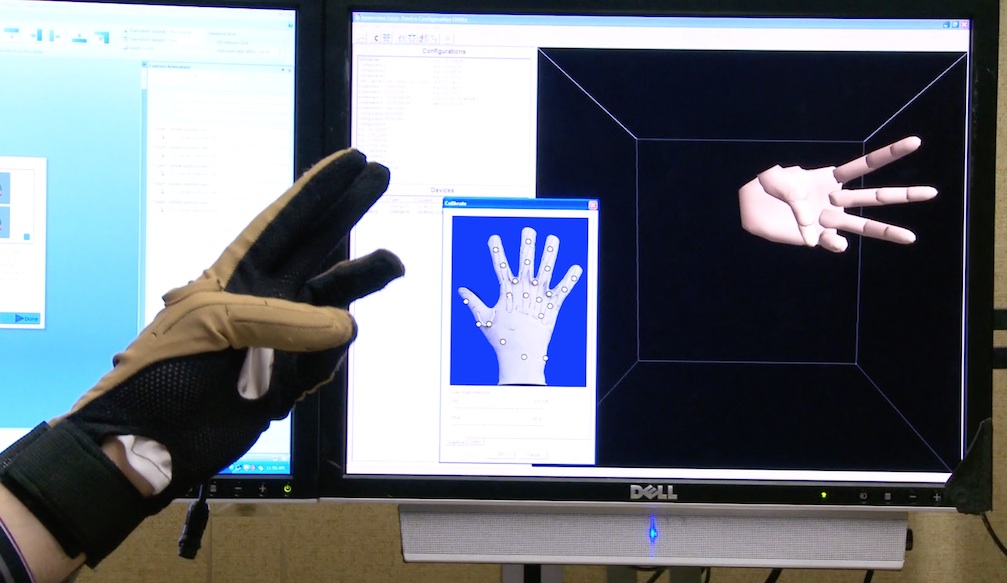 Cyberglove in front of computer screen showing the hand shape.